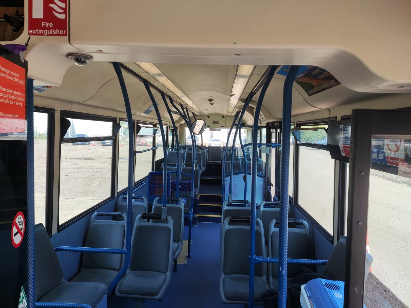 Inside a North Essex Travel bus, with blue grab rails and grey seats